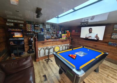Newcastle, Garage Conversion/Mancave and Spa with Timber Firring Base, Reclaimed Pine Floorboards, Reclaimed Spliced Oak studded 100mm Kingspan Walls, 3m x 1m Skypod Sky Lantern, Rustic Internal Lighting with Spotlights, Custom Pool Table, Bespoke Bar and Whiskey Barrel Tables, UPVC Woodgrain Ceiling Cladding, Bespoke Copper Bar Optics, Retro 10,000 Game Arcade System, Breaking Bad Fruit Machine, Winmau Dartboard, Blade & Philips Perfect Draft Beer Pumps, Hardiplank Cement Fibreboard Anthracite Cladding, Black Ash Fascia, Anthracite Composite Decking, Bespoke Cladded Pergola with 30mm Polycarbonate Roof, REHAU Patio Doors and Windows, new Palm Spa Hot-Tub and Black Porcelain Patio, Spots & Push Flush Toilet with Remote Interior Flashing Lighting and UPVC Cladded Walls Project